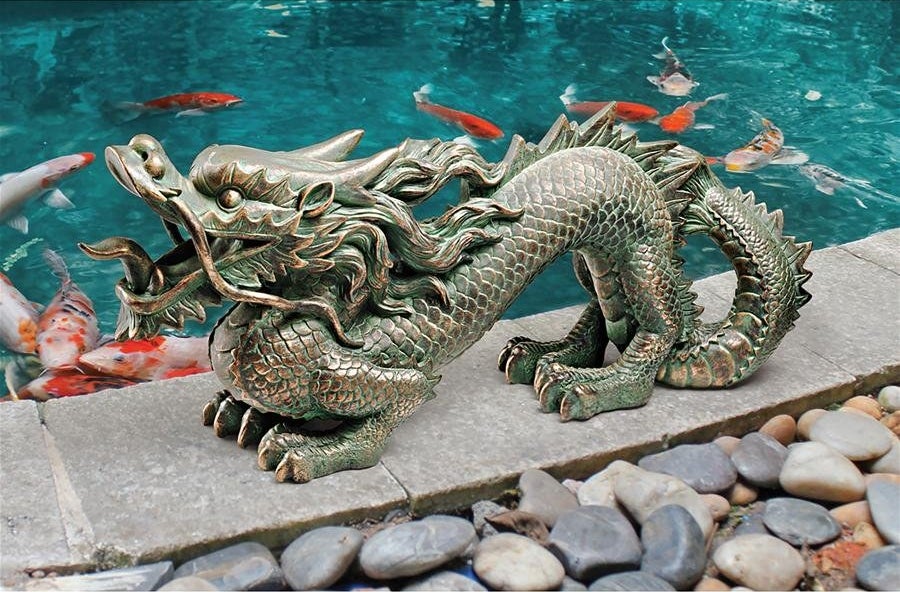 The green and gold dragon statue, in front of a koi pond