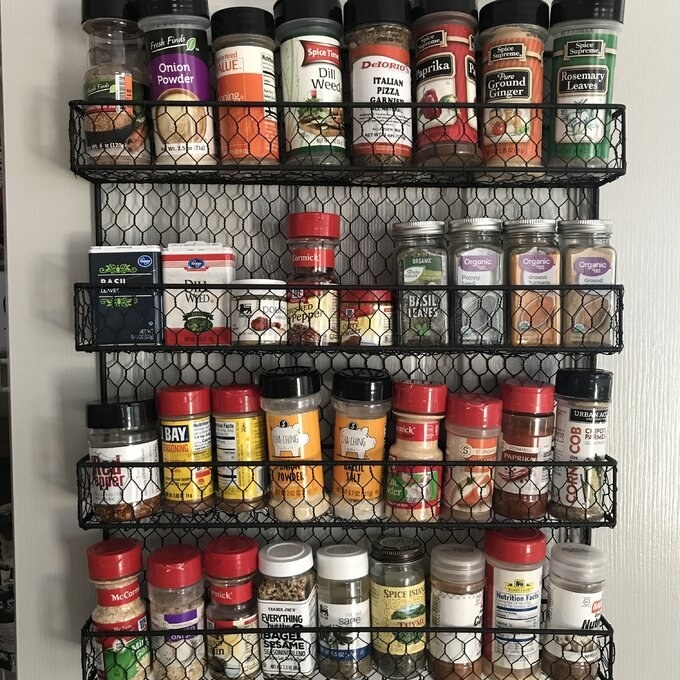 Reviewer&#x27;s picture of the spice rack displaying spices on back of door