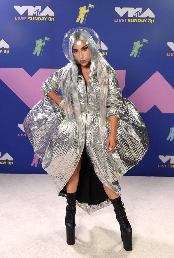 Lady Gaga poses at the VMAs with a fish bowl on her head
