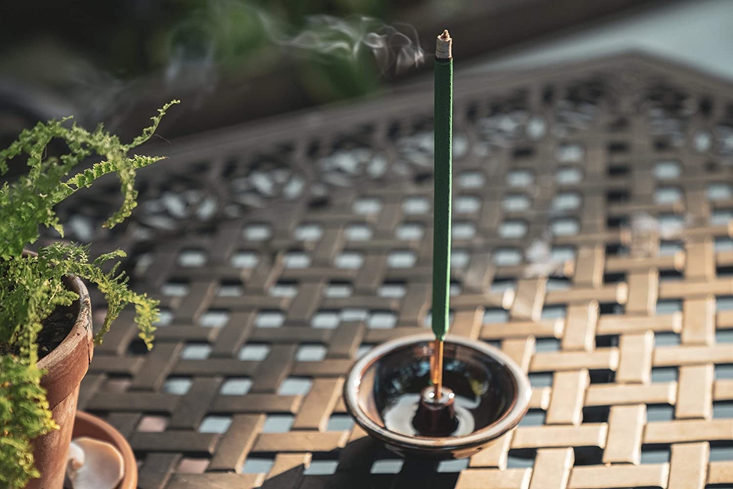 The green stick burning in an incense holder