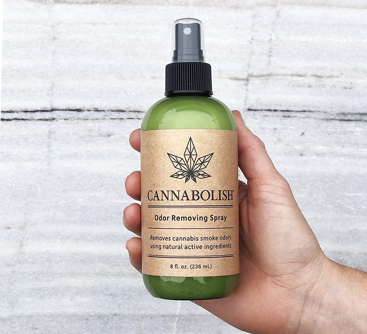 A person holds a bottle that says cannabolish