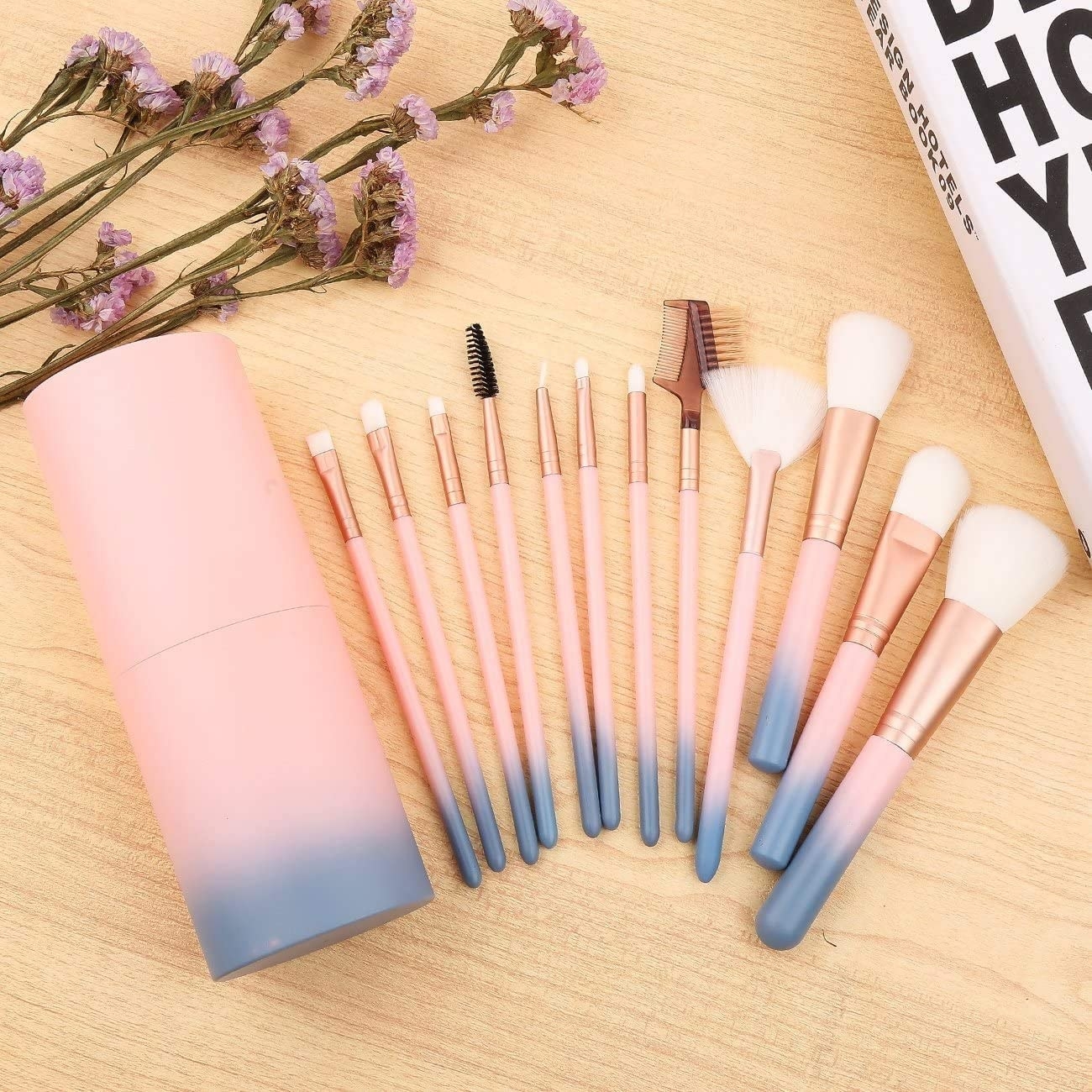 A flatlay of all the makeup brushes fanned out on a wooden counter