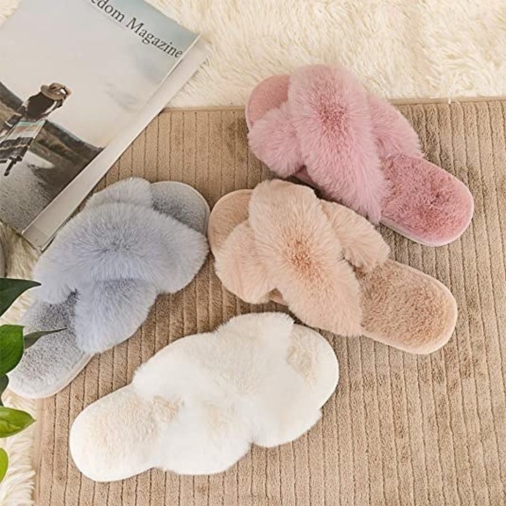 A flatlay of four fuzzy slippers in different colours