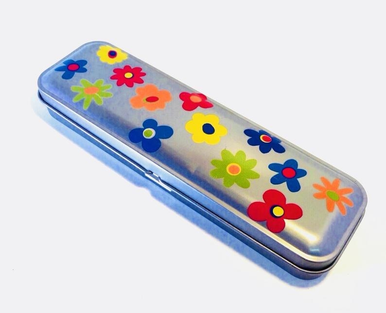 A tin pencil case with early &#x27;70s style flowers on it