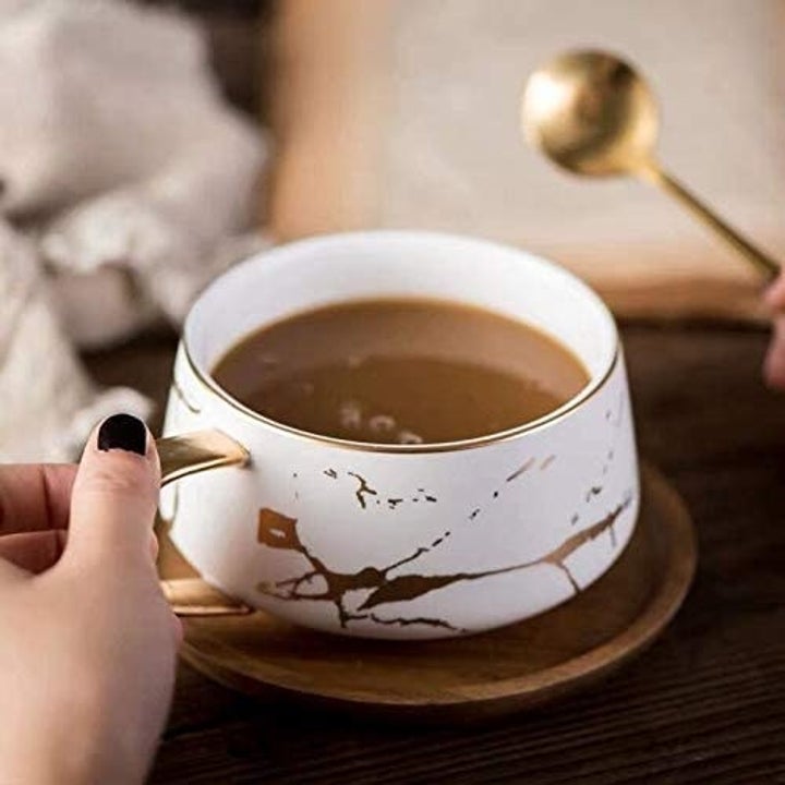A person reaches for the marbled mug  