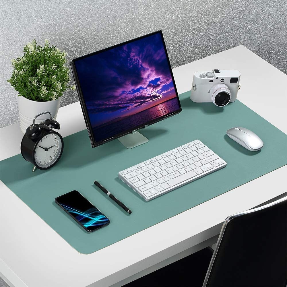 A large faux leather desk pad covers desktop with a computer, keyboard and mouse on it