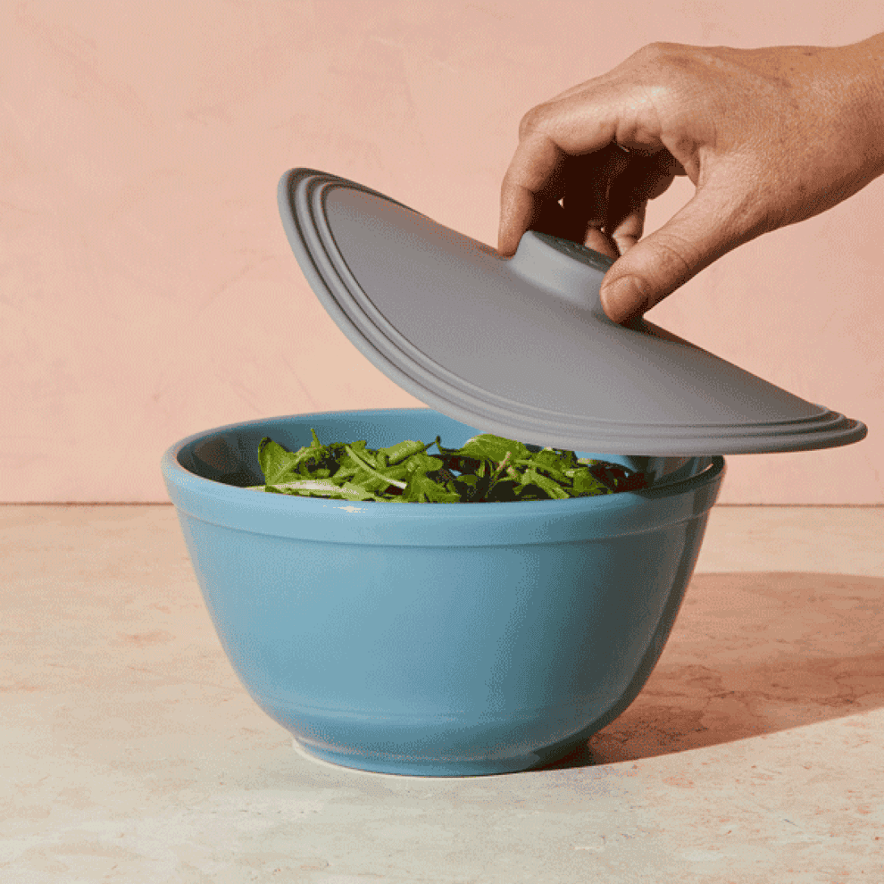 gif of silicone lid being place on a bowl then the bowl being lifted by the lid&#x27;s handle from the suction