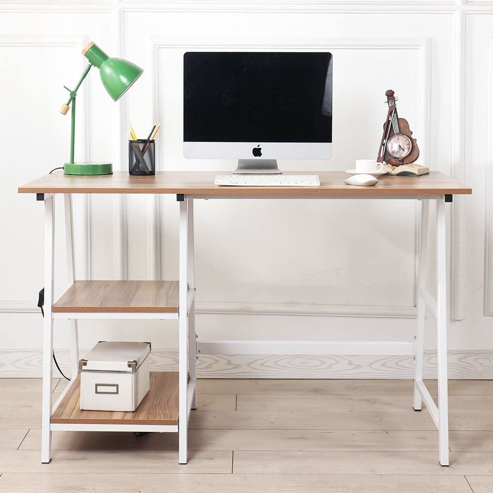 A small wooden desk with a laptop and lamp on the top There are two built-in shelves underneath with a small box on one