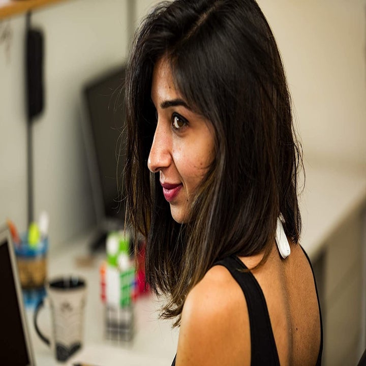 A person wearing the posture correcter just below their neck.