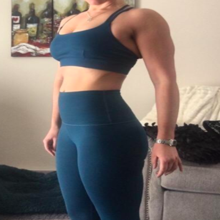 Reviewer shows front view of blue criss-cross sports bra 