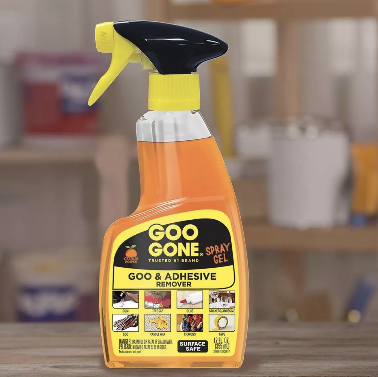Bottle of Goo Gone Goo &amp;amp; Adhesive Remover with orange liquid inside on a countertop