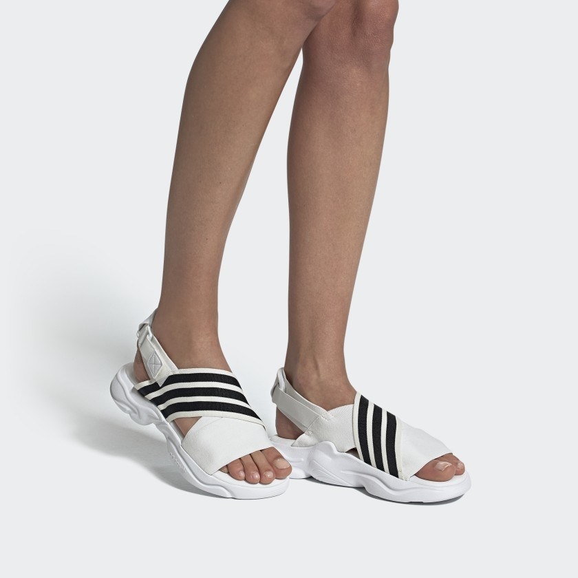 Model in the white sandals with black stripes on one strap