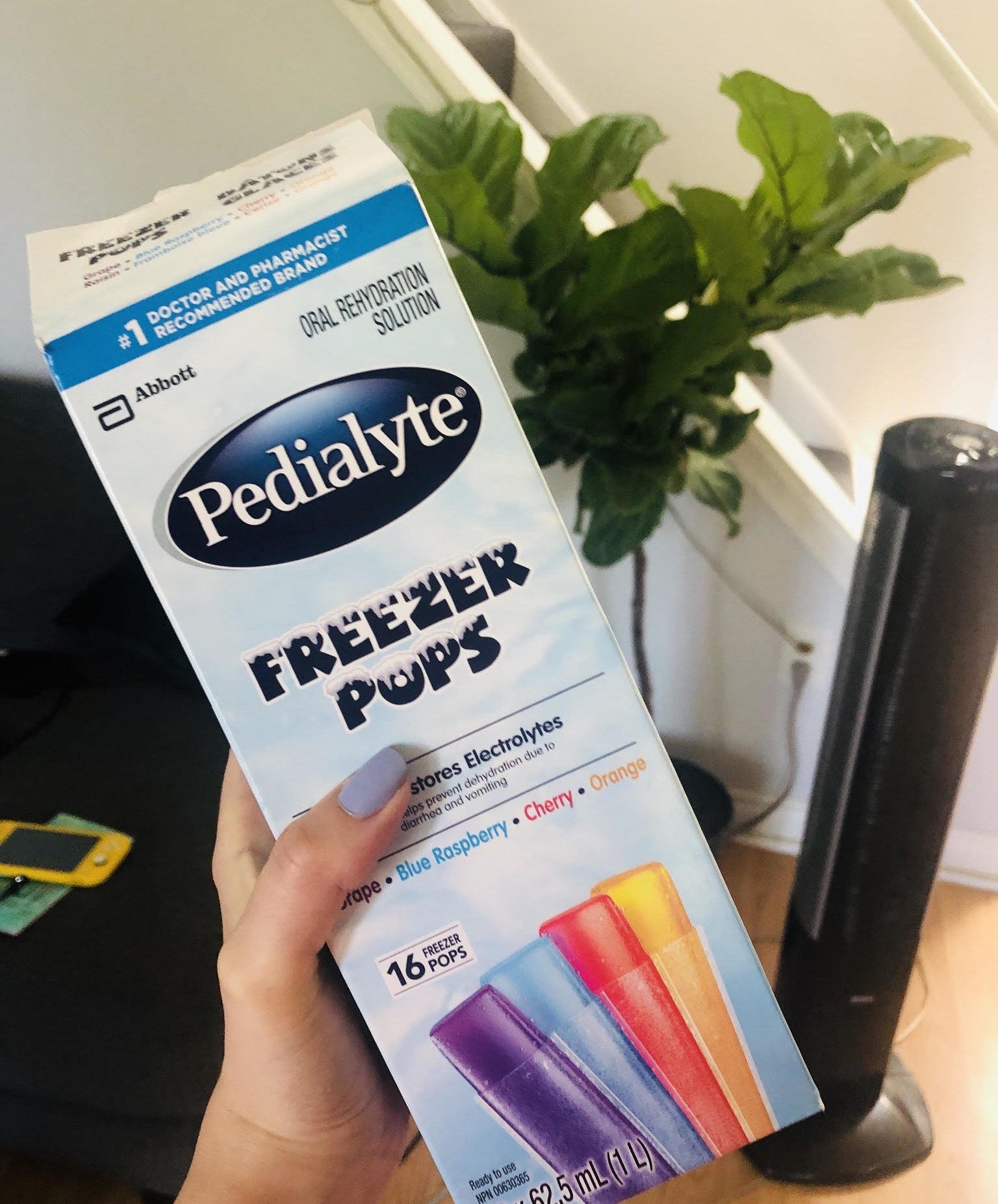 A person holding a box of Pedialyte freezies