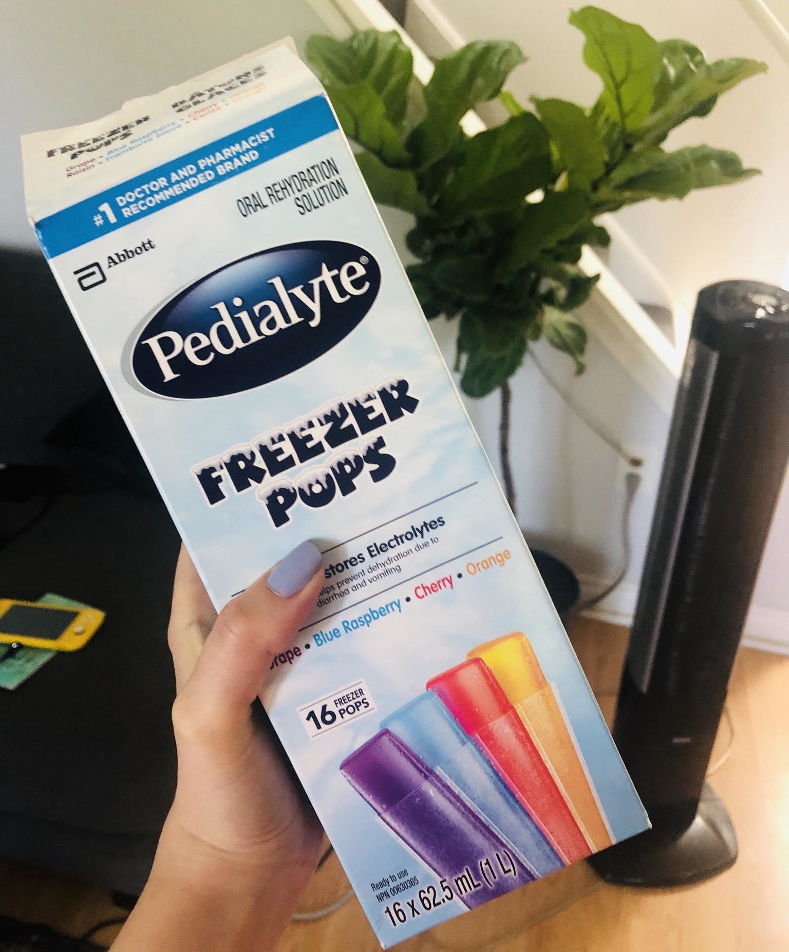 A person holding a box of Pedialyte freezies