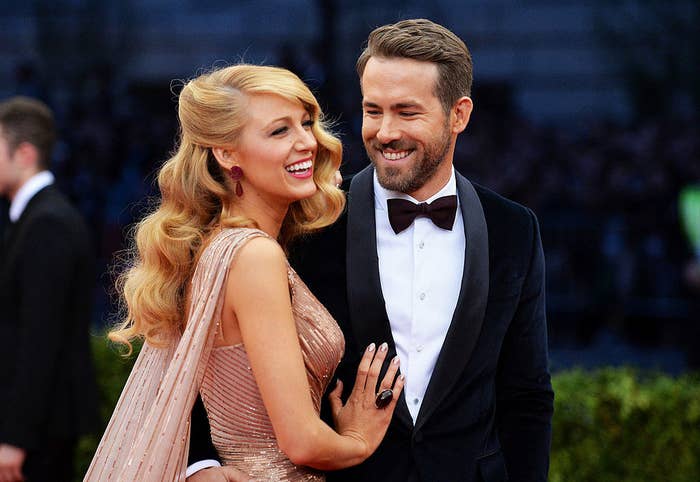 Blake Lively and Ryan Reynolds smiling on a red carpet