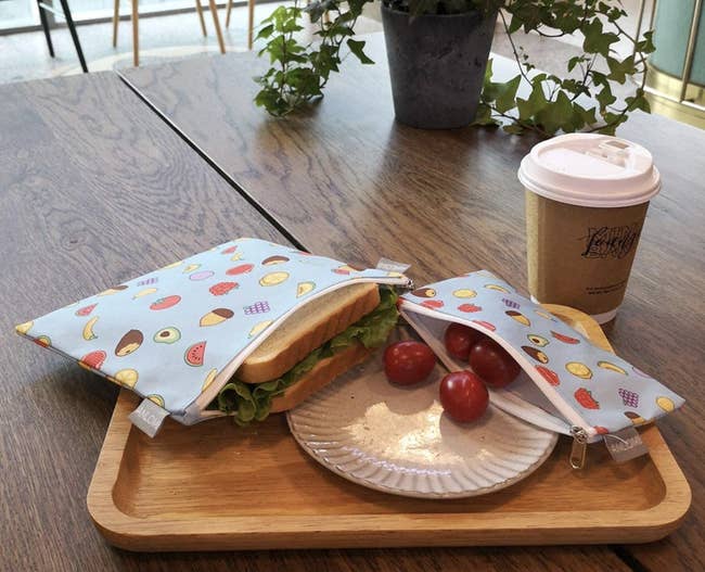 A sandwich size and snack size bag with a sandwich and tomatoes in them 