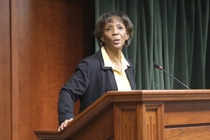 Jackie Lacey speaks at a wooden podium into a microphone.