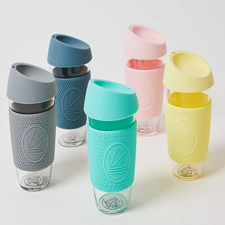 The glass cups with gray, blue, light blue, light pink, and yellow silicone toppers 