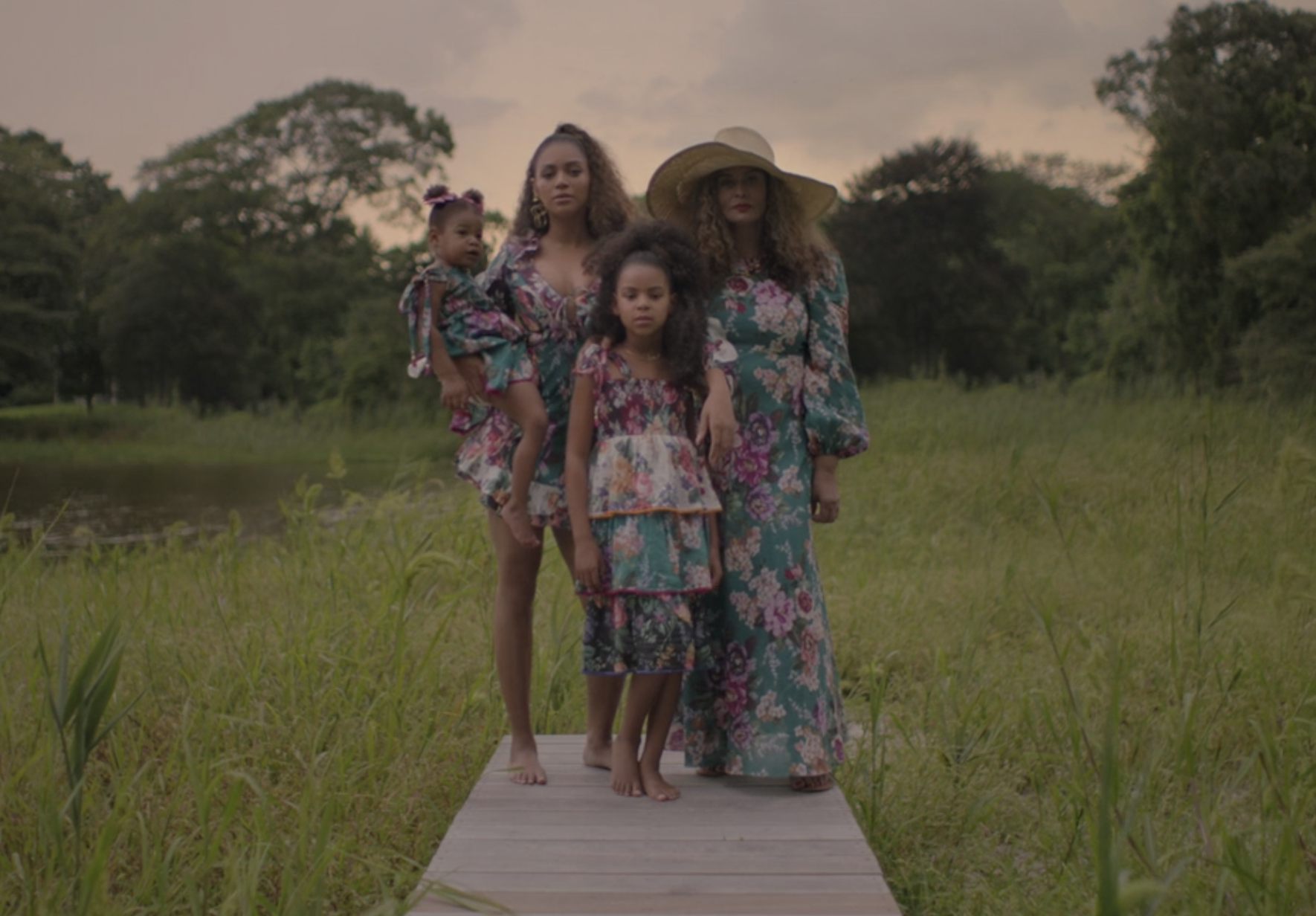 Tina Knowles, Beyoncé, Blue Ivy, and Rumi standing together in matching floral outfits