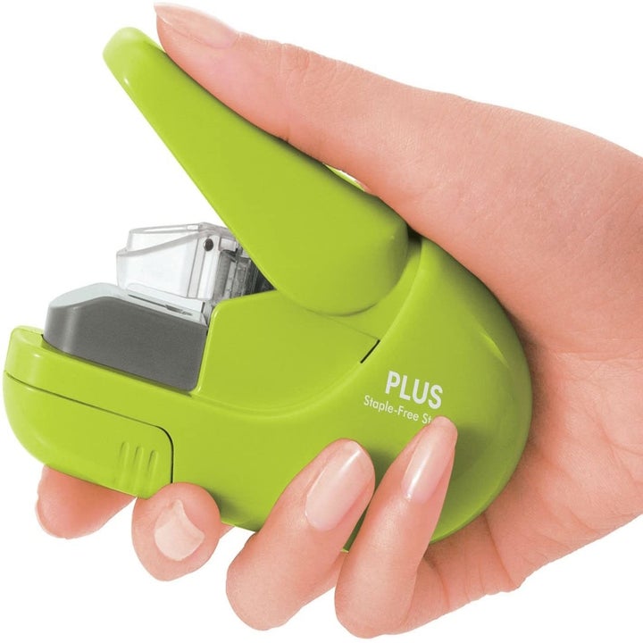 A person holding the staple-free stapler