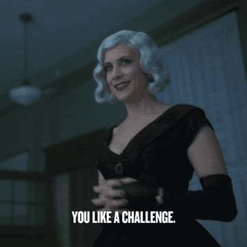 The Handler in a black dress, saying &quot;You like a challenge&quot;