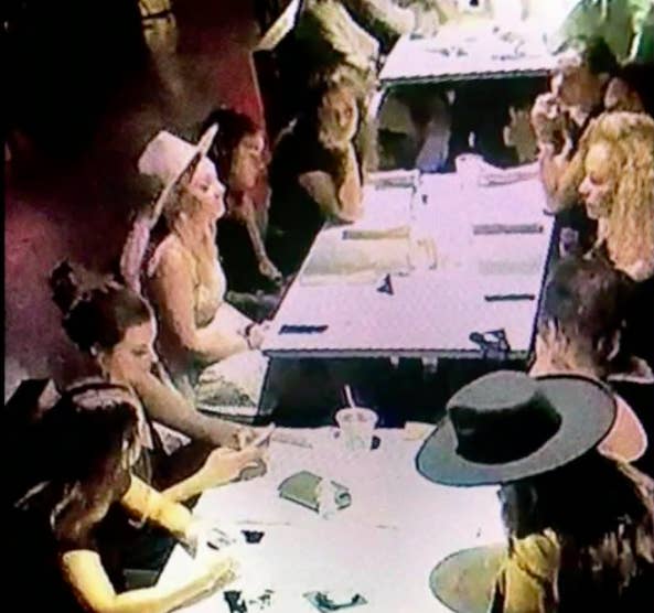 A security camera screenshot of nine women sitting at two tables at the Mockingbird restaurant.