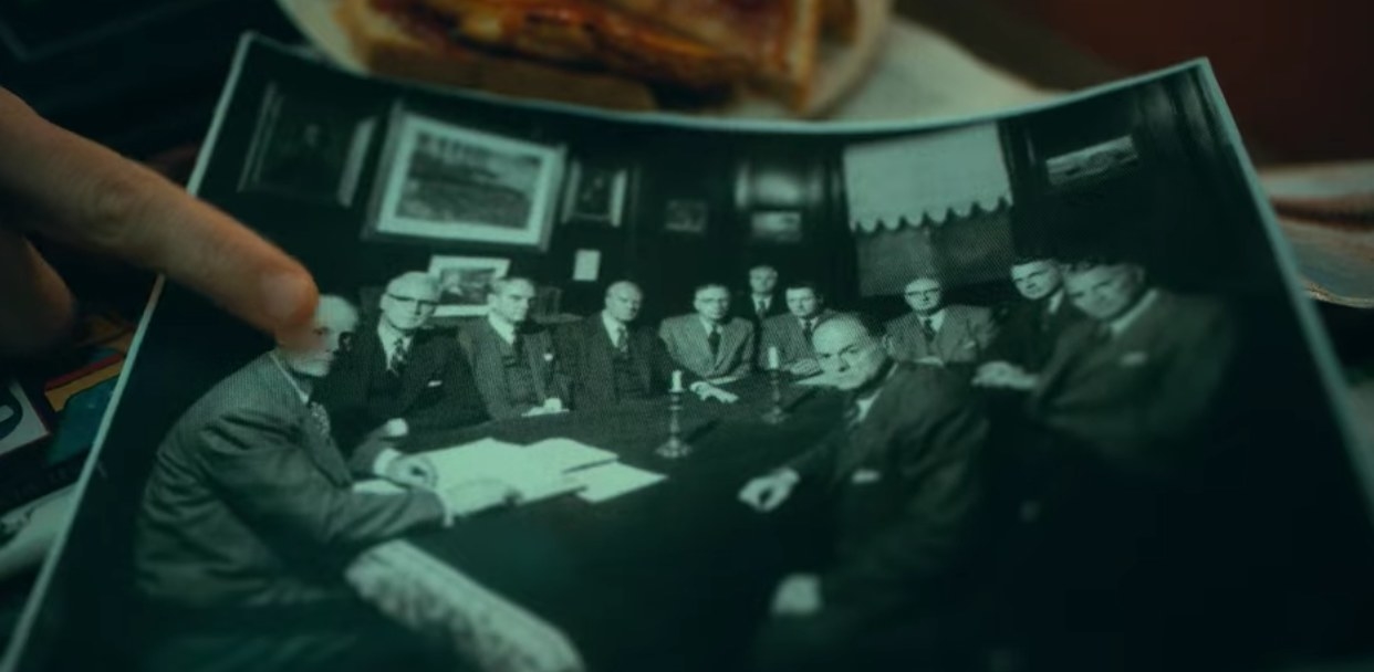 A black-and-white photo of ten men sitting at a table.