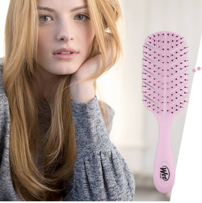 A model posing next to the pale pink brush 