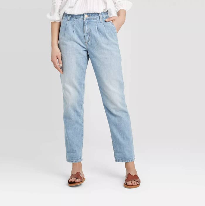 Model wears light blue high-rise cropped jeans with brown sandals