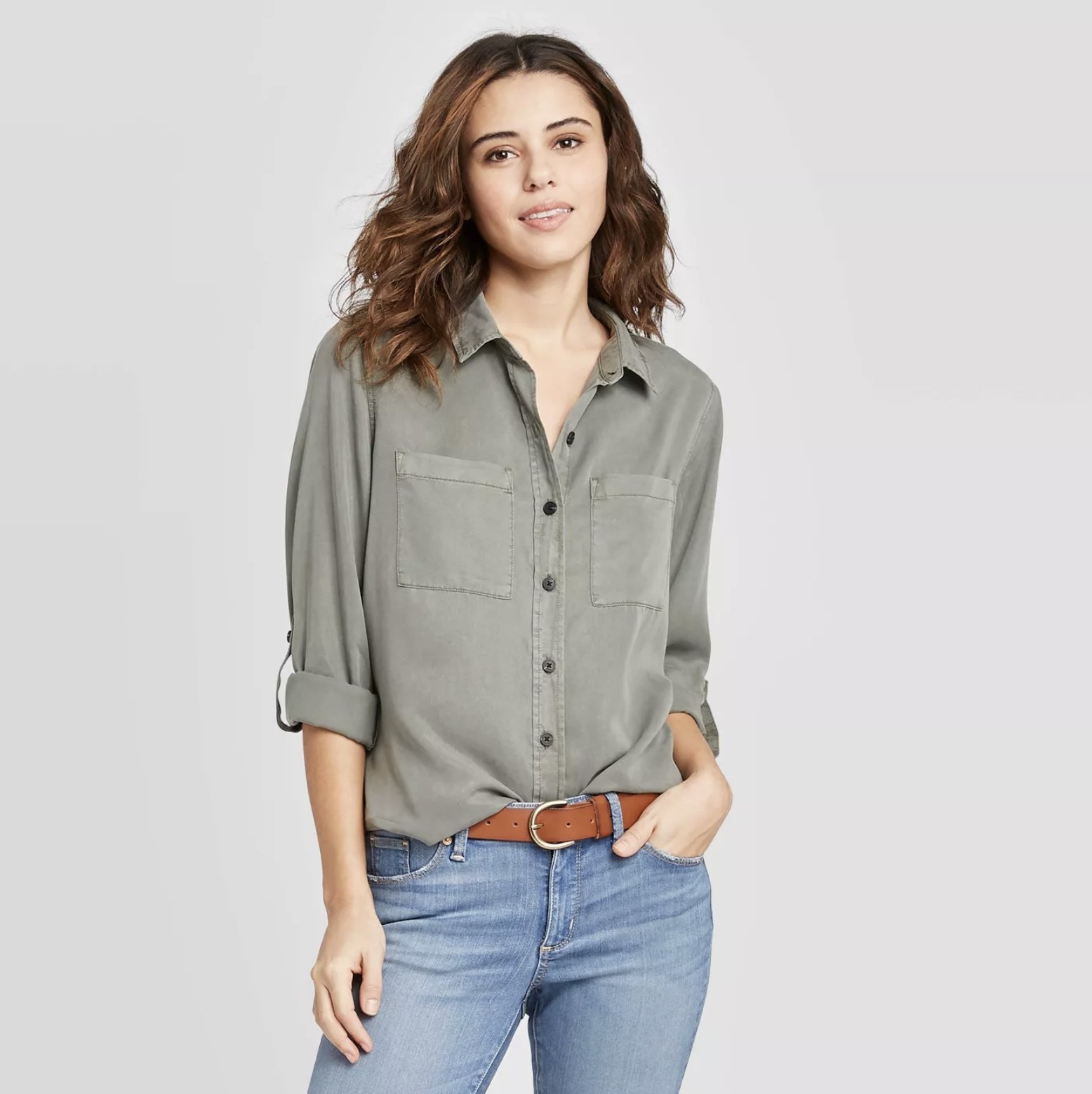 Model wears gray long-sleeve button-down shirt with light blue jeans
