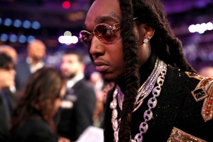 Takeoff wears sunglasses, chain necklaces, and a jewel-encrusted outfit