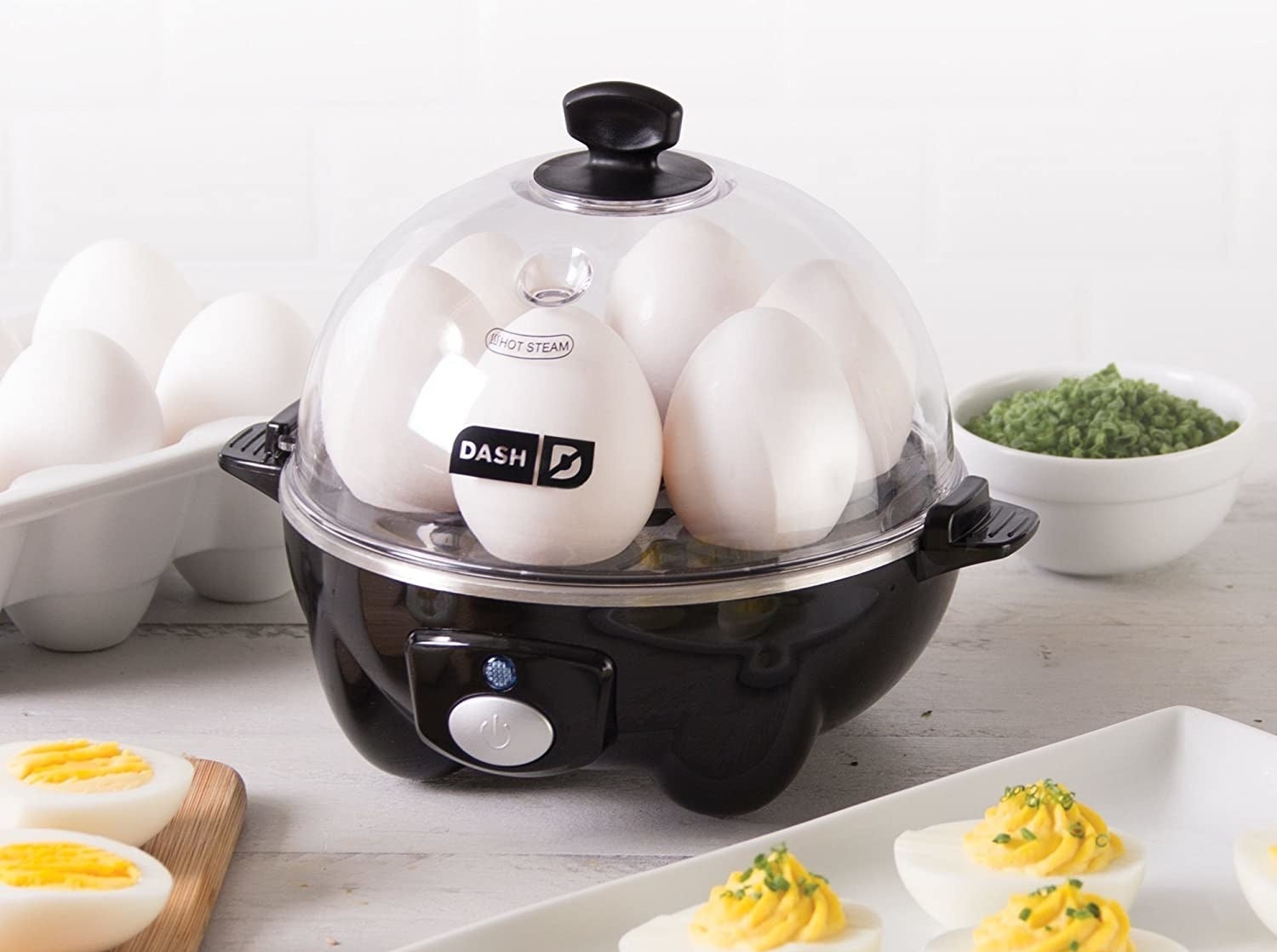The egg cooker in black filled with six eggs