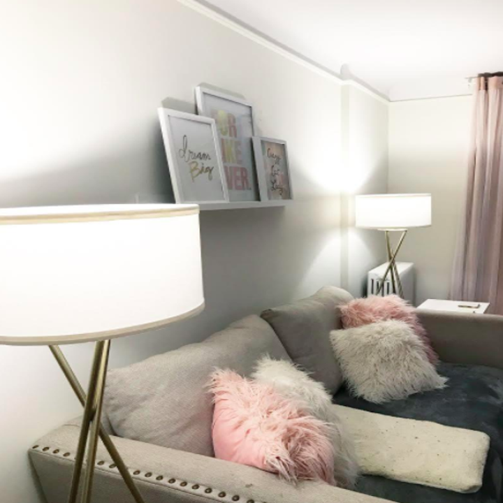 A customer review photos of the Jaxon Tripod LED Floor lamp on each side of someone's sofa