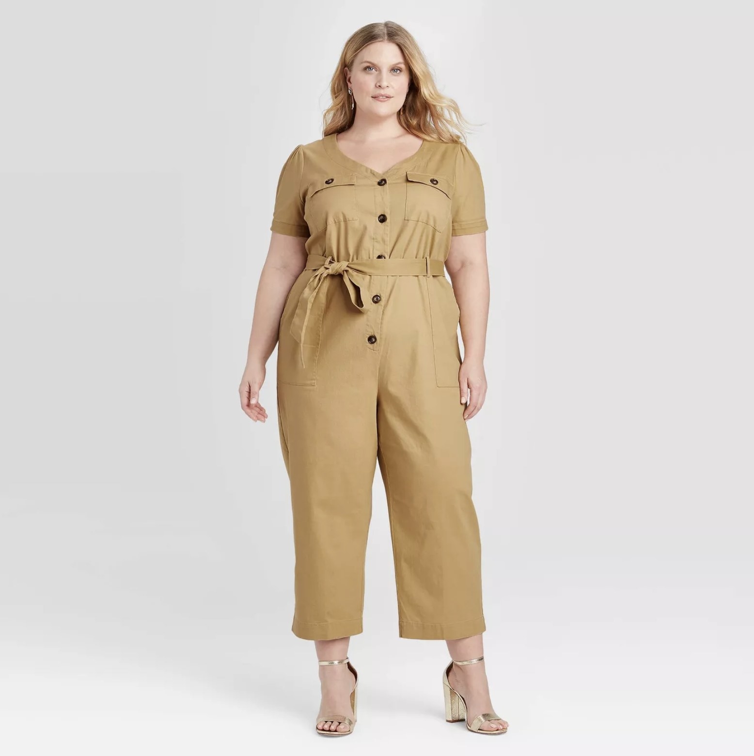 Model wears tan utility jumpsuit with matching heels