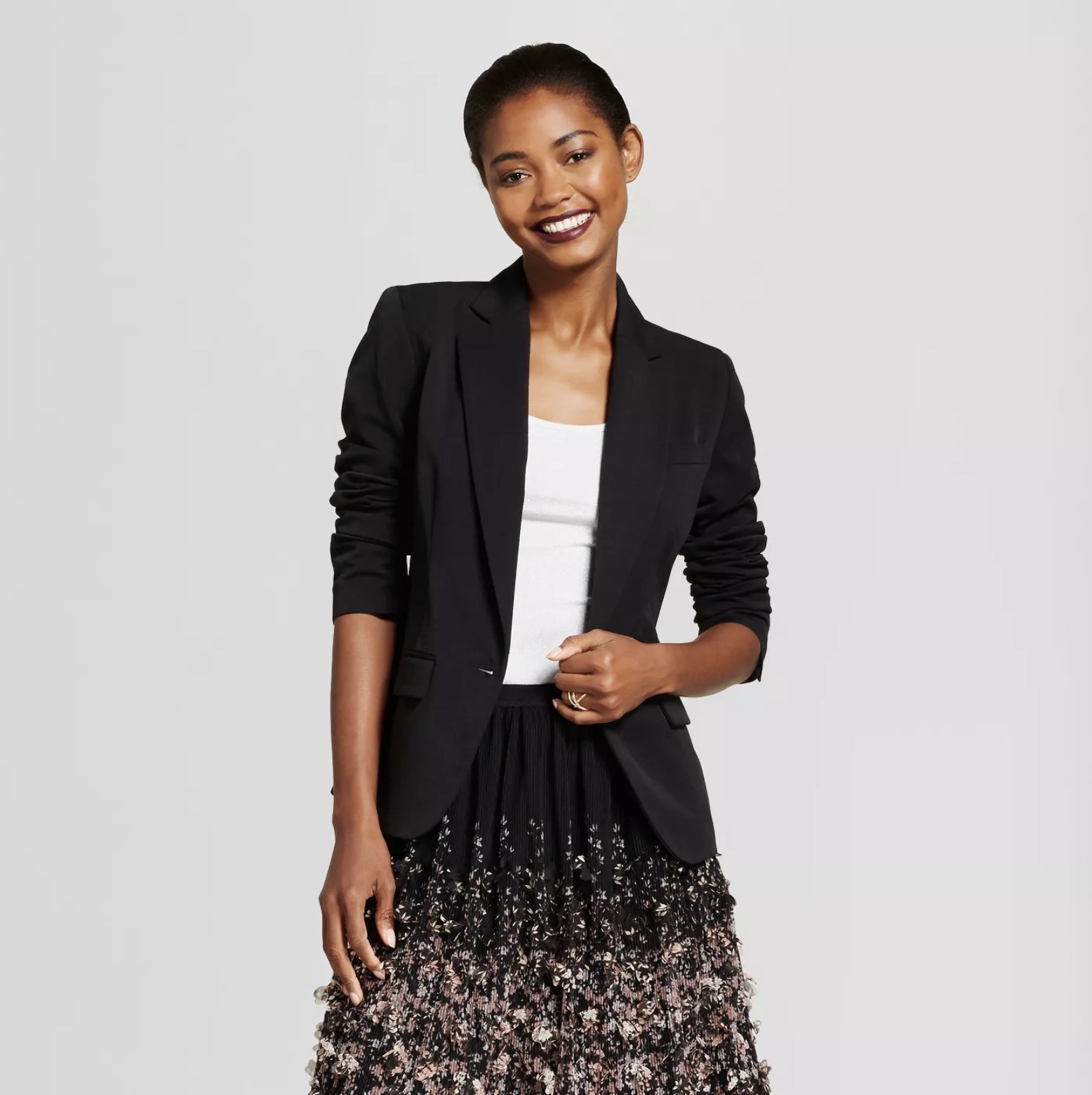 Model wears black twill blazer with floral skirt