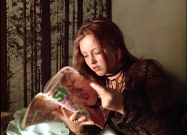 Ginger reads a magazine with a woman on the cover