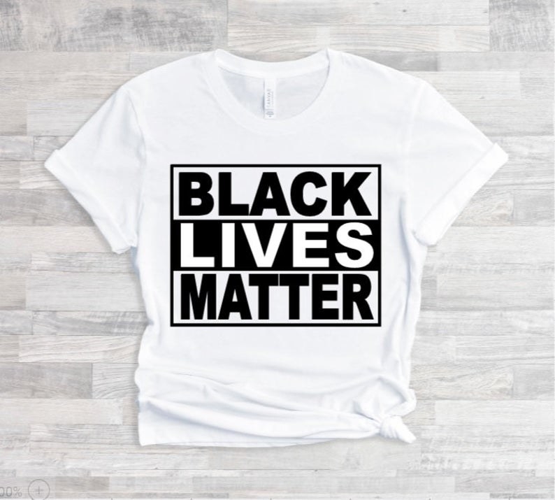 A tee shirt that says black lives matter on a wooden background 