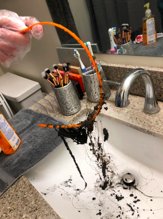 A reviewer using the drain snake to remove hair from their drain 