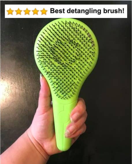 Reviewer&#x27;s hand holding the green detangling brush with five-star Amazon caption &quot;best detangling brush&quot;