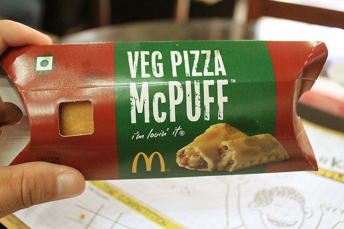 Image of a person holding a Pizza McPuff from McDonald&#x27;s India.
