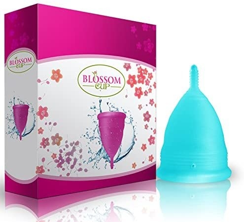 The menstrual cup in blue next to the box