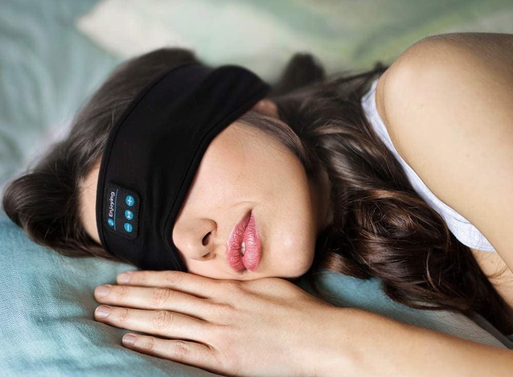 A person sleeping with the headphone headband over their eyes