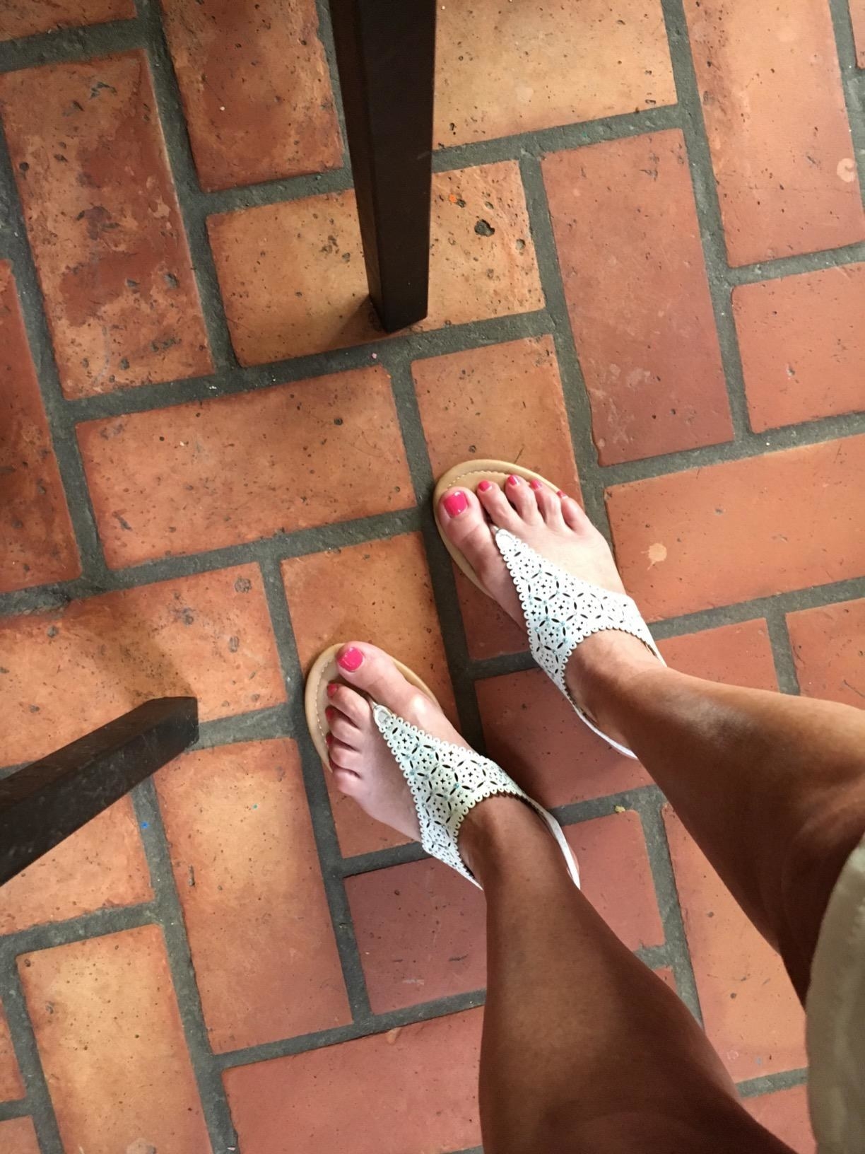 Reviewer&#x27;s feet in the white sandals