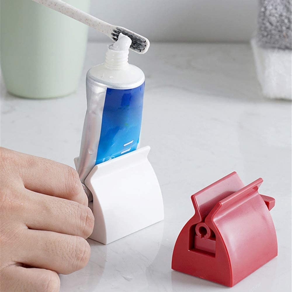 A toothpaste stand with a flat base that allows toothpaste to sit upright on a counter. The stand twists to ensure that all toothpaste easily gets out of the tube, preventing waste.