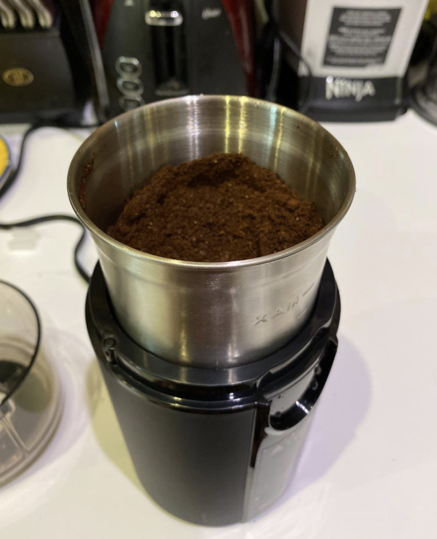 Reviewer image of the grinder full of ground coffee beans 