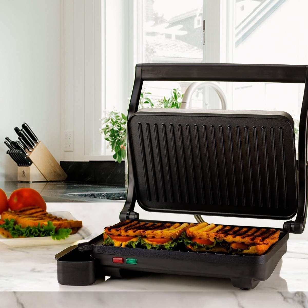The panini press with a grilled sandwich inside