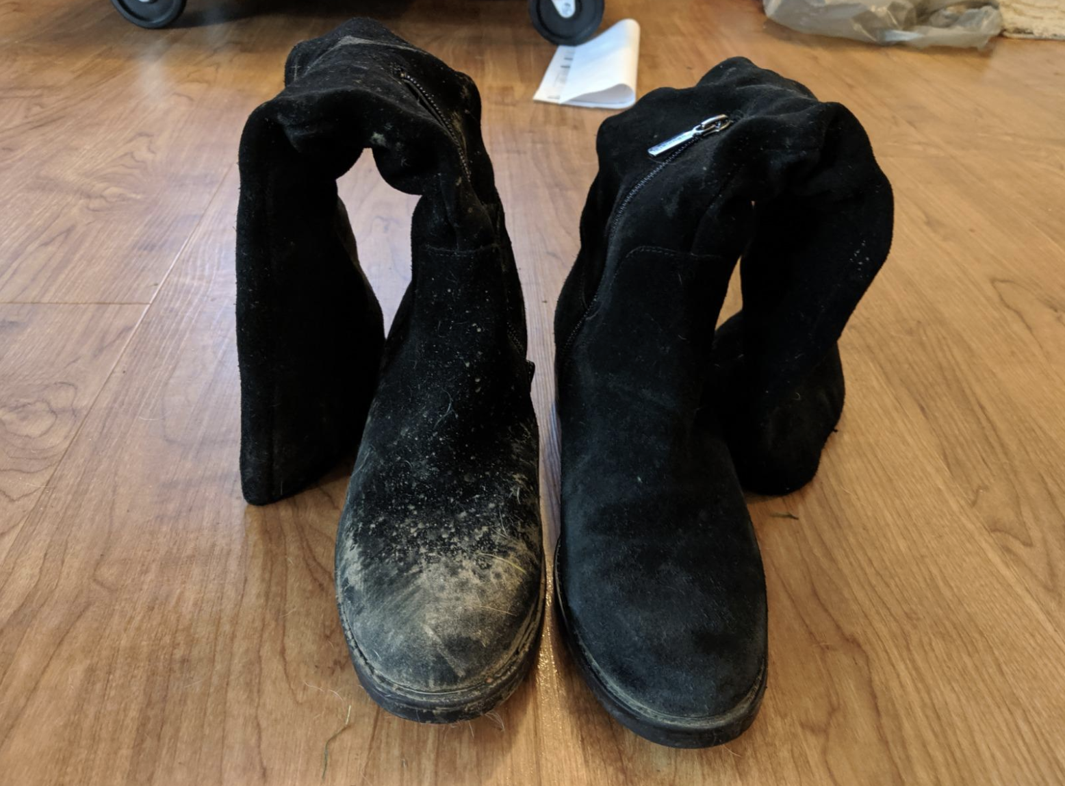 Reviewer image of their boots, one is covered in scuffs and stains and the other is clean from the brush
