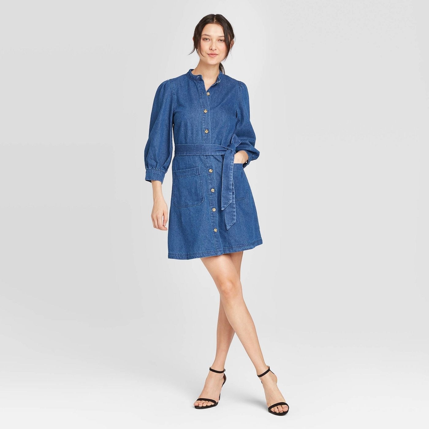 Model in long sleeve button up denim dress with tie waist 