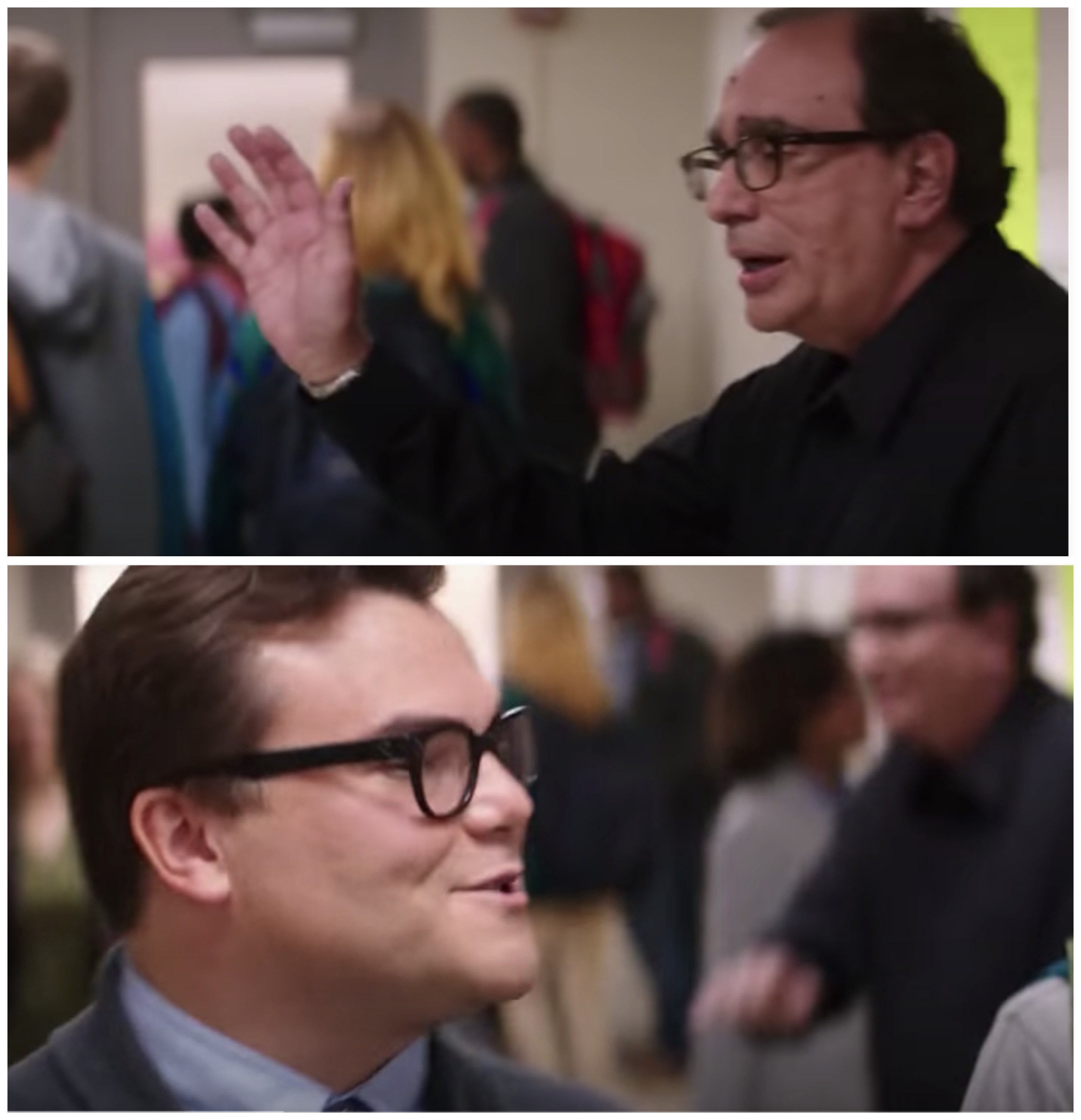 R.L. Stine waving to Jack Black who waves back in a school hallway