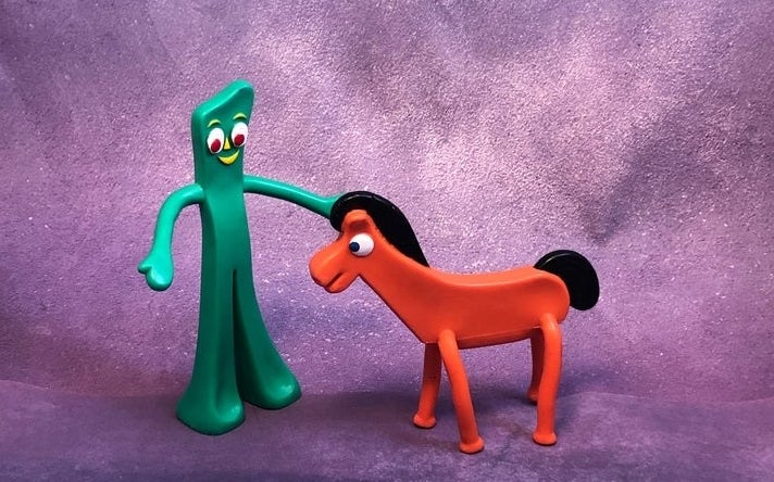 Gumby and Pokey figures standing against a purple backdrop.